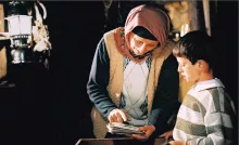 Mehmet, le fils des voisins, aime passer du temps à écouter les histoires d'Ayshe.