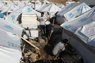 Dans le camp provisoire de Kara Tepe qui a remplacé celui de Moria à Lesbos, des réfugiés réparent une tente endommagée par un orage le 14 octobre.