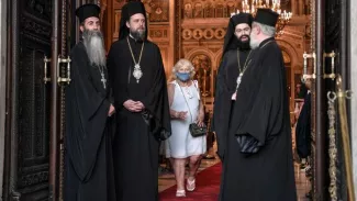 Des prêtres grecs orthodoxes se tiennent à l'entrée de la cathédrale d'Athènes, le 24 juillet dernier. LOUISA GOULIAMAKI/AFP


