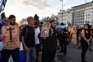 Un Grec orthodoxe manifeste le 29 août 2021 devant le Parlement à Athènes contre l'obligation vaccinale pour les personnels de santé entrée en vigueur quatre jours plus tôt. PHOTO / LOUISA GOULIAMAKI / AFP


