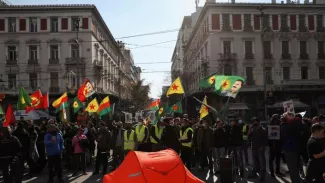 Des manifestants agitent des drapeaux devant un canot de sauvetage, le 6 février 2022, pour protester contre le refoulement de migrants et la violence à la frontière gréco-turque, après la découverte de 19 corps de migrants morts de froids non loin de cette zone. LOUIZA VRADI / REUTERS


