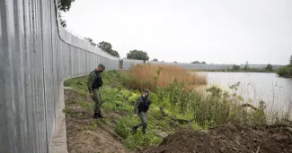 Des policiers grecs patrouillent devant une clôture en acier le long du fleuve Evros délimitant une frontière fluviale avec la Turquie. Giannis Papanikos/AP


