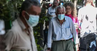 Des piétons marchent dans la rue en portant un masque, dans le nord de la Grèce, le 18 mai 2022 (photo d'illustration).