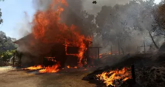 Une maison brûle sous l'effet du Oak Fire près de Mariposa en Californie, le 23 juillet 2022.


