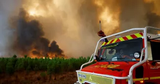 Des pompiers tentent de ralentir l'incendie menaçant la commune de Belin-Beliet en Gironde, le 10 août 2022.


