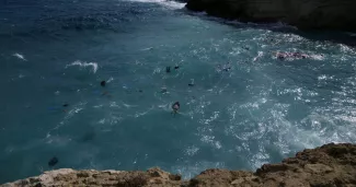 Des corps de migrants à côté de débris flottants après qu'un voilier transportant des migrants se soit écrasé contre des rochers et ait coulé au large de l'île de Cythère, dans le sud de la Grèce, jeudi 6 octobre 2022.


