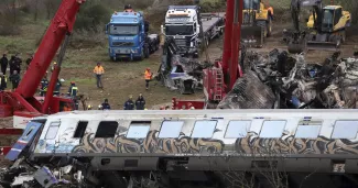 Deux grues tentent de retirer des débris des voies ferrées, à Tempe, à environ 376 kilomètres au nord d'Athènes, près de la ville de Larissa, en Grèce, le 2 mars 2023. — © Vaggelis Kousioras / keystone-sda.ch


