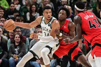 La star des Bucks, Giannis Antetokounmpo, protège son ballon devant les joueurs de Toronto OG Anunoby et Pascal Siakam, dimanche soir (118-111). (Benny Sieu/Usa today sports)


