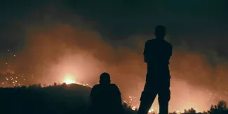 Des personnes regardent les incendies près du village de Malona, sur l'île grecque de Rhodes, le 23 juillet.  © SPYROS BAKALIS / AFP


