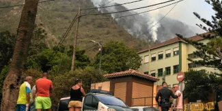 Un garde civil s'entretient avec des habitants de La Orotava alors qu'un incendie de forêt hors de contrôle fait rage à travers les pentes boisées de l'île canarienne de Tenerife, le 19 août 2023.