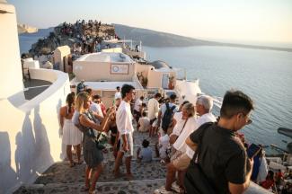 Oia - Une coulée de chapelles blanches coiffées de coupoles bleues qui dégringole dans la mer Egée, des baisers d'amoureux et des poses de jeunes femmes en talons hauts : Santorin, île très « instagrammable » de Grèce, est prise d'assaut par les amateurs de selfies et de photos