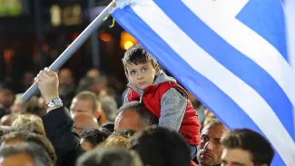 Un enfant sur les épaules de son père, vendredi, lors d'un meeting de Syriza.


