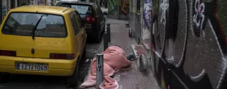 Un sans-abri dort dans une rue d'Athènes. © ANGELOS TZORTZINIS / AFP


