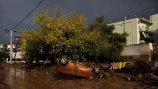 Une voiture renversée dans une rue à Mandra (nord-ouest d'Athènes), le 16 novembre 2017 au lendemain d'importantes inondations


