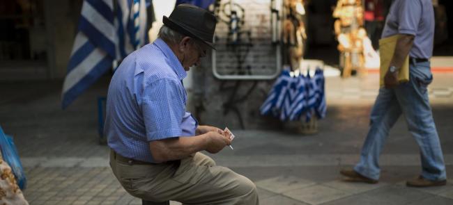 Alors que les banques sont encore fermées dans le pays, un homme compte son argent dans une rue d'Athènes. Crédits photo : Emilio Morenatti/AP


